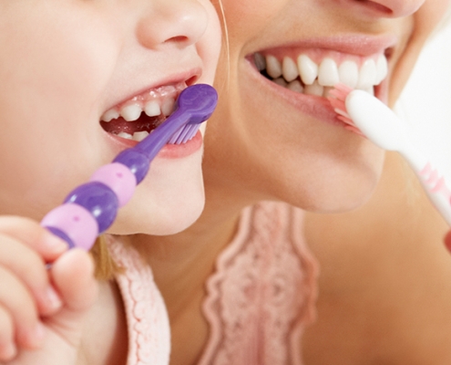 Mother and Daughter Brushing Teeth